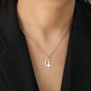 Cat sitting on a crescent moon necklace
